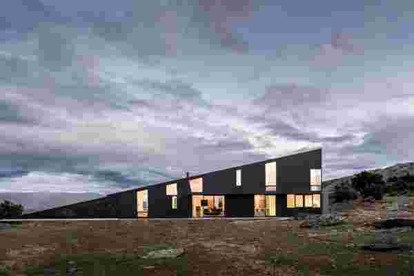 This wedge-shaped home features curved wood ceilings and stone flooring to echo New Zealand’s surrounding landscape!